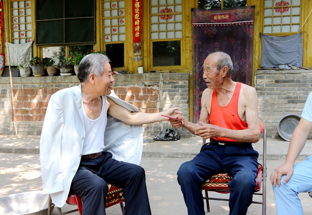 张喜伟 与农村老干部了解农业生产发展情况.jpg